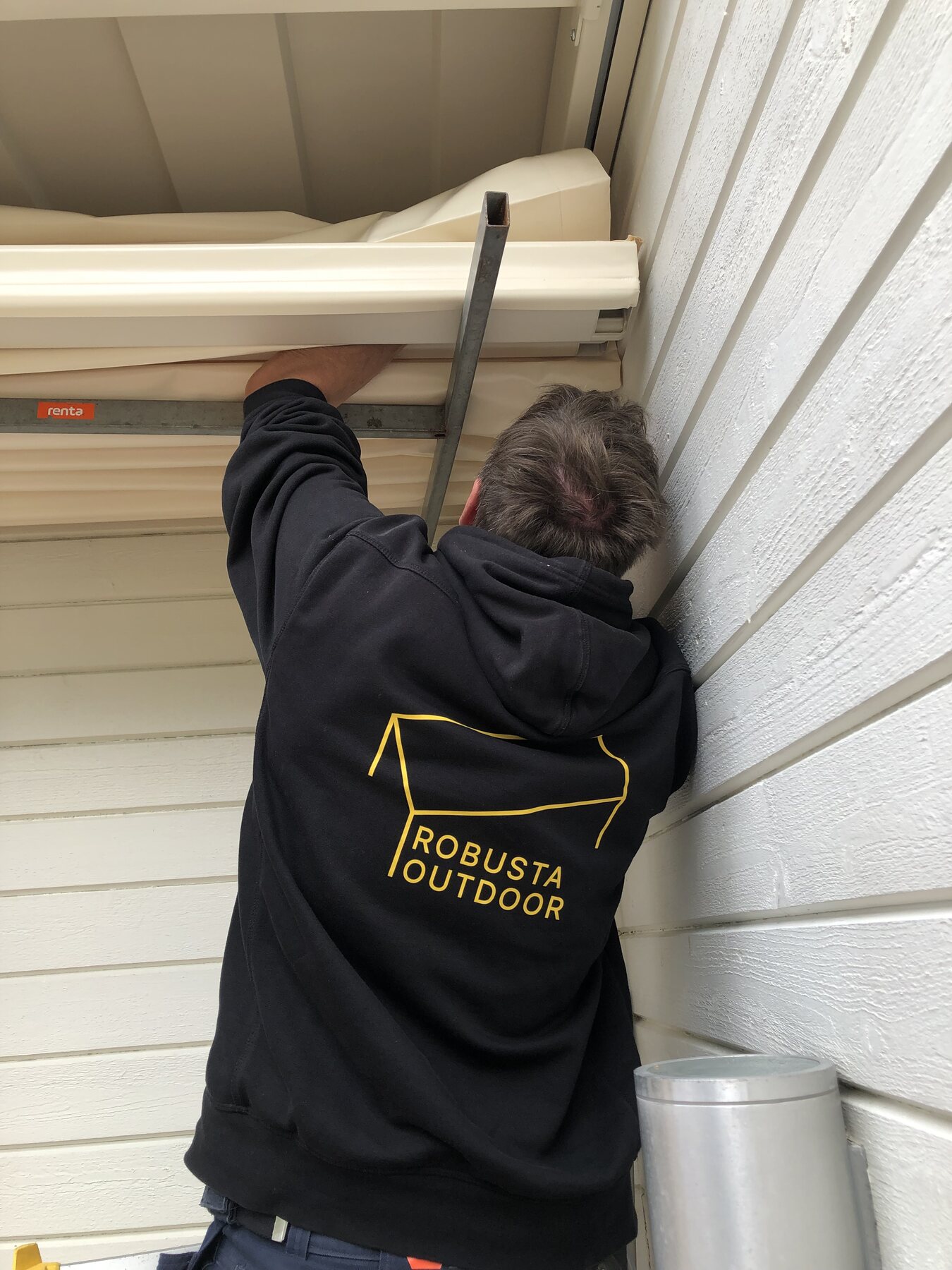 Robusta Outdoor monterar en markis under takfoten på en villa