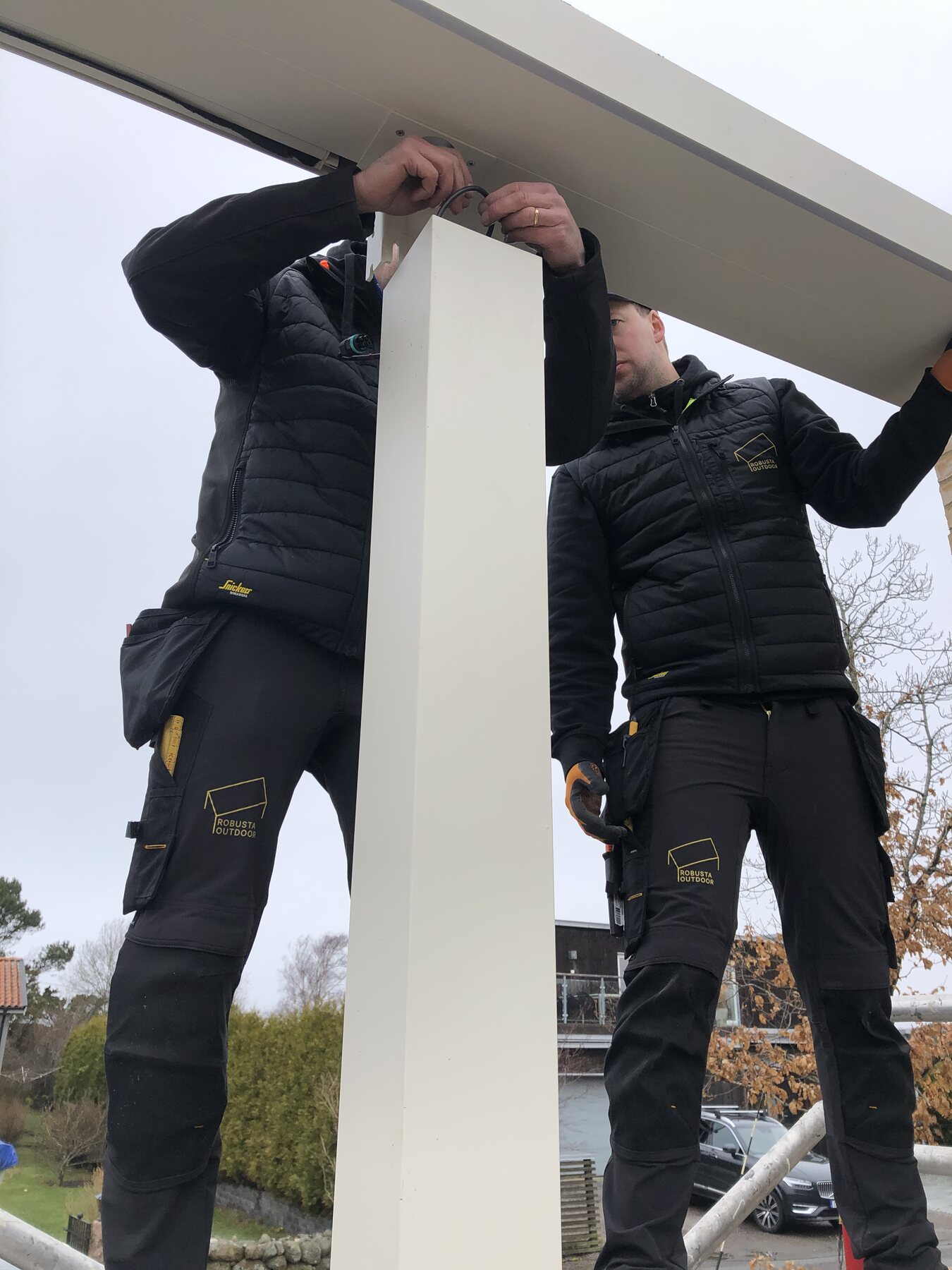 Robusta Outdoors montörer installerar en Pratic-pergola